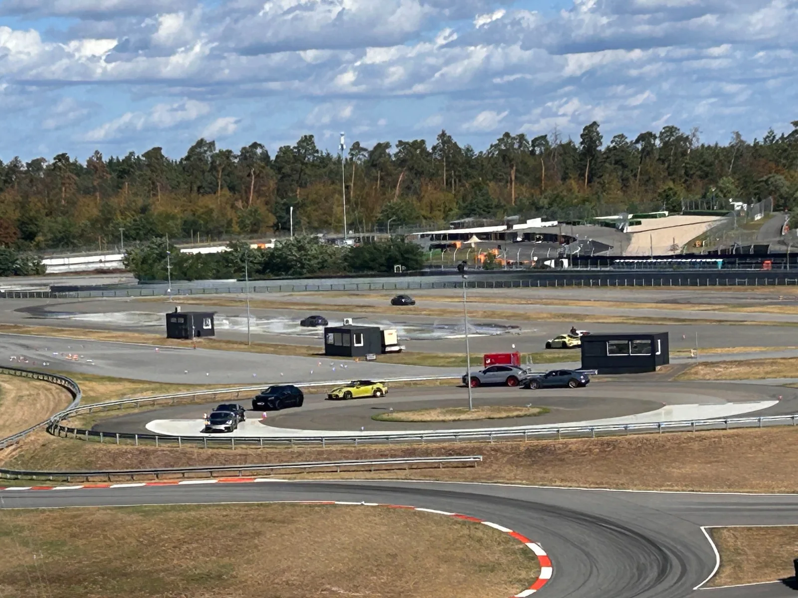 Several cars moving through the driving areas at Porsche Experience Center Hockenheimring