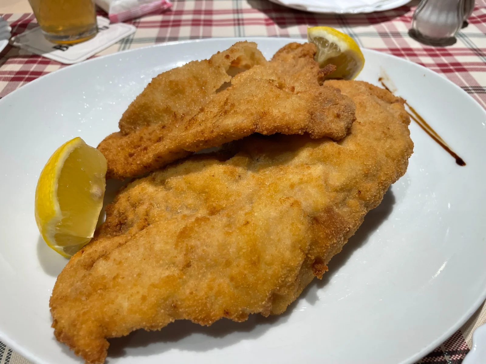 Golden breaded Schnitzel Wiener Art with lemon wedges at Römer Pils Brunnen